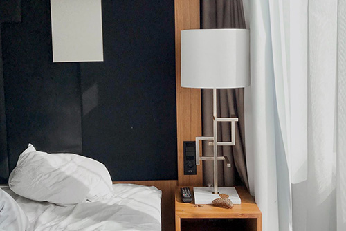 A bedside table with modern lamp. Achieve greatness with our tidy up tricks.