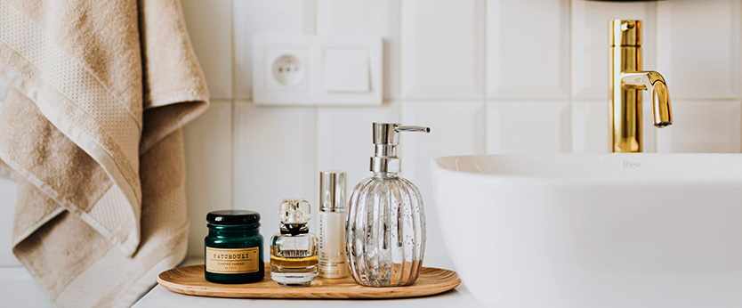 A modern bathroom with bamboo tray and golden water tap. Embark on success with our tidy up tricks.